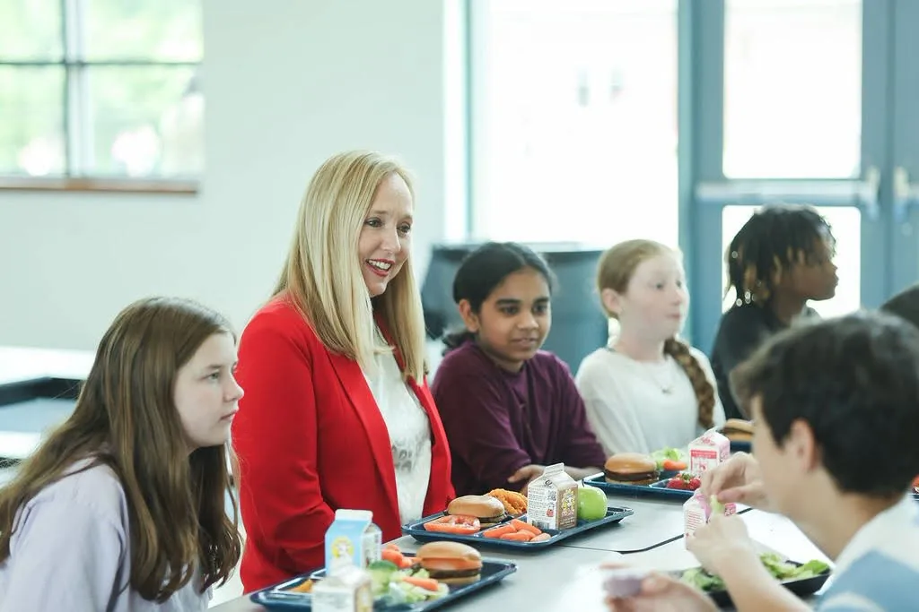 Ashley Powell talking with students in a school cafeteria
